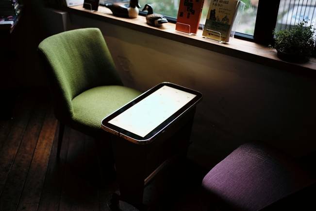 A tablet on a table beside a chair